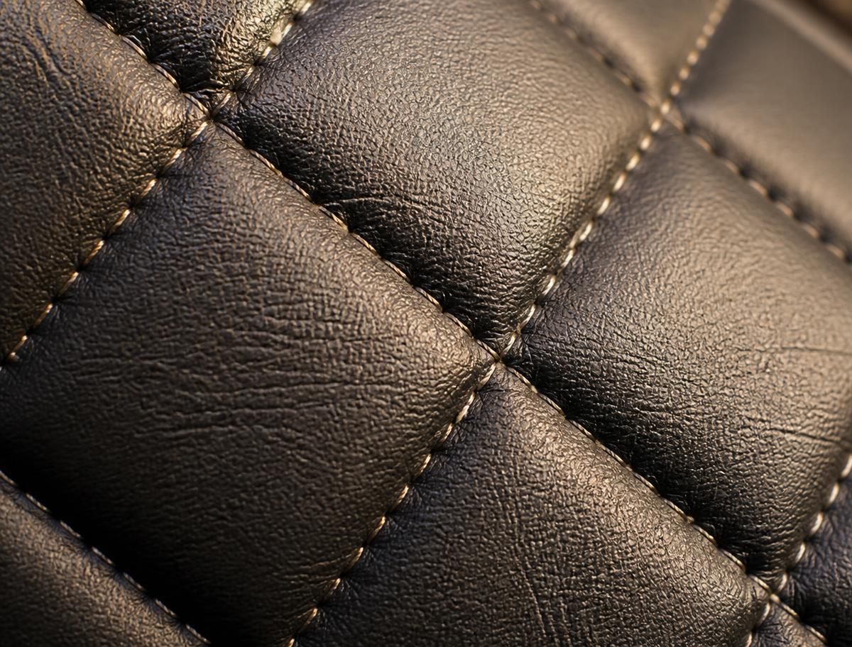 Macro detail of diamond quilt stitching on leather upholstery